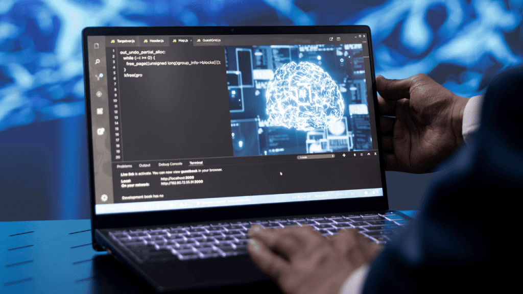Pessoa usando um notebook com tela exibindo códigos e uma representação digital de um cérebro, simbolizando desenvolvimento de inteligência artificial, tecnologia e análise de dados.