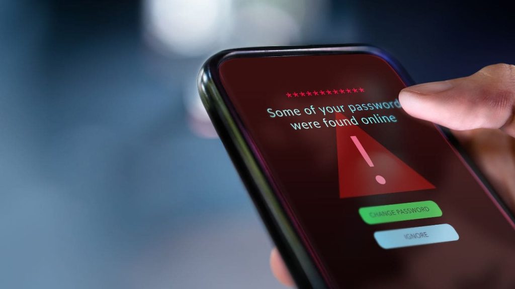 Celular exibindo alerta de segurança sobre senhas expostas, representando riscos de cibersegurança, proteção de dados e vulnerabilidades em sistemas críticos.
